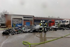 Einsatzkräfte löschen den brennenden Plastikabfall von mehreren Seiten ab.
