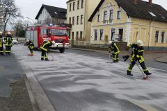 Einsatzkräfte der Feuerwehr streuen die Dieselspur mit Bindemittel ab.