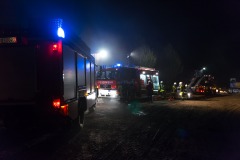 Einsatzkräfte bereiten den Innenangriff unter Atemschutz sowie eine Drehleiter für Löscharbeiten von außen vor.
