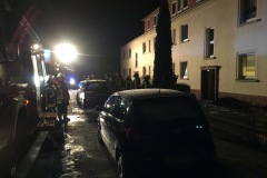 Einsatzfahrzeuge und Einsatzkräfte der Feuerwehr vor dem Objekt.