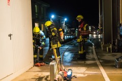 Ein Atemschutztrupp bereitet sich auf die bevorstehende Menschenrettung aus dem verrauchten Gebäude vor.
