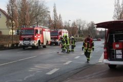Einsatzkräfte der Feuerwehr beim abstreuen der Ölspur im Stadtgebiet.