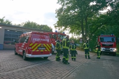 Fahrzeuge und Einsatzkräfte stehen am Feuerwehrhaus in Scharnhorst in Bereitstellung.