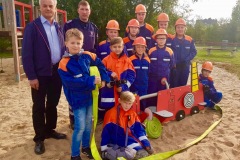 Die Jugendfeuerwehr Hönisch-Hutbergen mit dem neuen Feuerwehrauto auf dem Spielplatz am Ziegeleiweg. Mit dabei Ortsbürgermeister Wolfgang Hammer und Jugendwart Daniel Teubert.