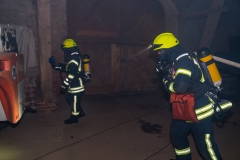 Feuerwehrleute unter Atemschutz durchsuchen die Scheune nach den vermissten Technikern. Feuerwehrleute unter Atemschutz durchsuchen die Scheune nach den vermissten Technikern.
