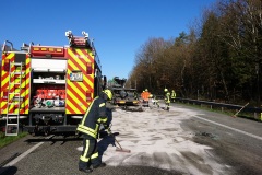 Einsatzkräfte der Feuerwehr streuen ausgelaufenen Kraftstoff ab.