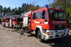 Einsatzfahrzeuge der Feuerwehr vor dem Brandobjekt.