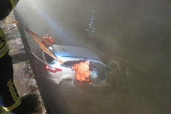 Einsatzkräfte der Ortsfeuerwehr Verden in Spezialanzügen an dem PKW.