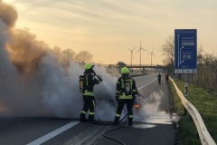 Einsatzkräfte löschen den in Vollbrand stehenden PKW.