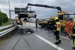 Einsatzkräfte löschen den in Vollbrand stehenden PKW.