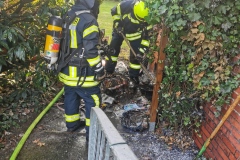 Löscharbeiten an einer brennenden Mülltonne am Sonntagnachmittag in Hönisch.