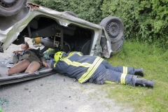 Rettung des Unfallopfers beim überschlagenen PKW.