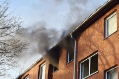 Dichter Rauch dringt aus den Fenstern der Brandwohnung.