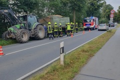 Einsatzkräfte bei Kühlmaßnahmen am Traktorgespann.