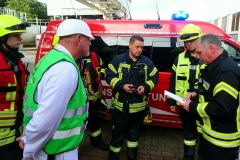 Feuerwehr und Mitarbeiter der Firma Mars bei einer Lagebesprechung.