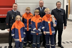 Die gewählten und geehrten Jugendlichen mit Jugendwart Florian Mesenbrink, Ortsbrandmeister Henning Paul und dem stellvertretenden Stadtjugendfeuerwehrwart Christian Müller (hinten, v.l.).