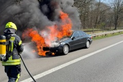 Flammen schlagen aus dem PKW.