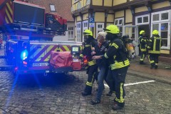 Ein Verletztendarsteller wird durch einem Atemschutztrupp in Sicherheit gebracht.