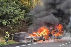 PKW und Anhänger brennen in voller Ausdehnung.