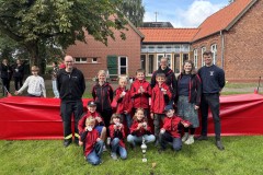 Die Kinderfeuerwehr Walle mit dem Wanderpokal und dem stellvertretenden Stadtbrandmeister Torben Voigt (links) sowie Stadtkinderfeuerwehrwart Cedric Schwarze (rechts).